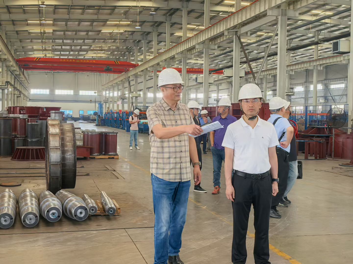 Project representatives wearing safety helmets during a visit to Ganquan’s pump workshop