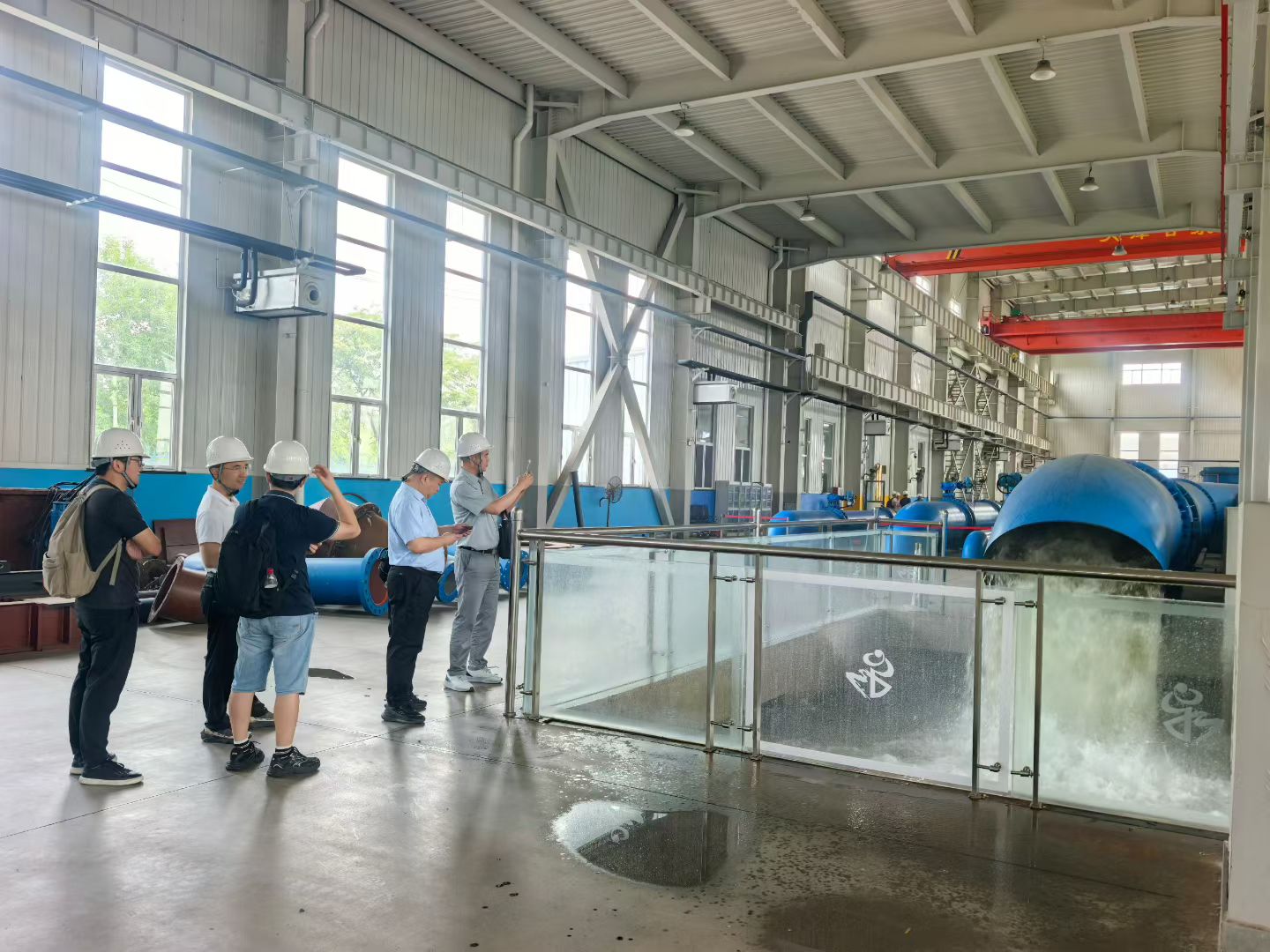 Project representatives observing water discharge at Ganquan’s pump test facility